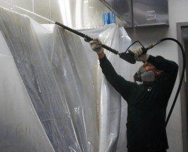 Pressure washing inside wrapped commercial kitchen hood.