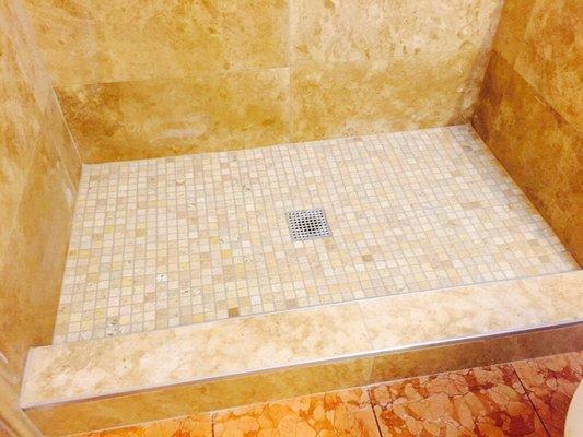 Shower floor with travertine tile.