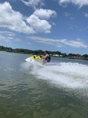 Young girl riding a yellow JetSki.