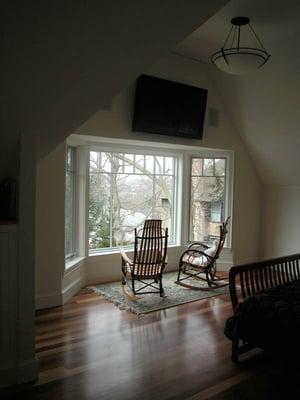 Master bedroom addition with flat screen TV installed over bay window in cathedral ceiling. Flooring made from Lyptus® a renewab