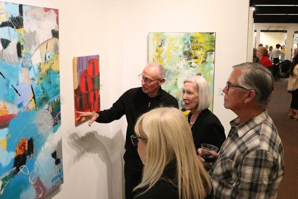 Artist Bob Hogue discussing his work with visitors to the gallery.