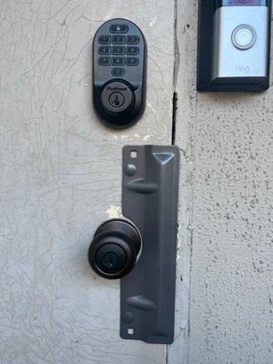 digital keypad deadbolt lock on residential door with door bell and plate cover on door knob