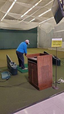 A store representative taking some golf strides in their testing area.