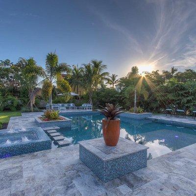 Large approximately 1000 sqft resort style custom pool with Infinity spa, raised glass tiled columns along with raised glass tile planters