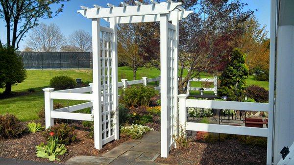 Arbor with vinyl ranch rail to add to this garden's appeal.