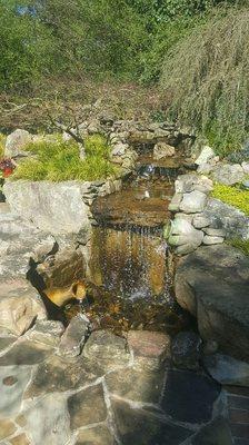 Waterfall and  new landscape transformed a plain hill into a beautiful sitting area.