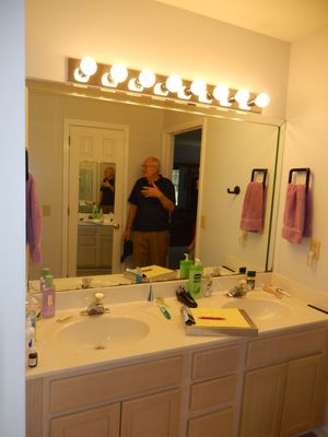 old vanity, mirror, old counter tops & light fixtures, old faucets.