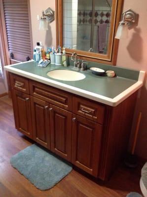 Cherry bathroom cabinet that was ting oiled and has aged to a deeper red patina. The mirror frame is also custom made.