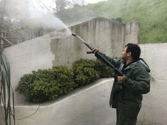 Pressure washing a patio wall