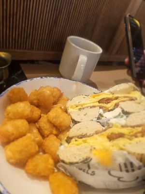 Bacon, egg and cheese on a poppy seed bagle, with chive cream cheese and tots