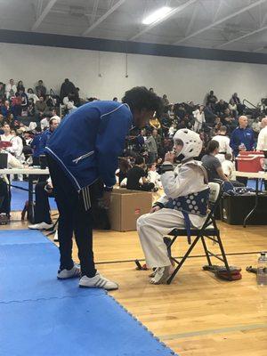 Assistant coach/black belt Maverick Kelly with an athlete at a tournament