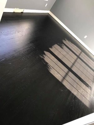 True black stain on a red oak floor with a satin finish.