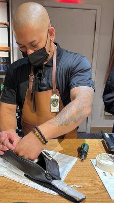 Leather craftsman Andrew customizing a belt bag