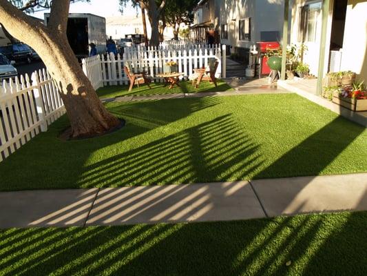 Artificial turf installed in three separate lawns with outdoor furniture and a large tree in Redwood City, California.