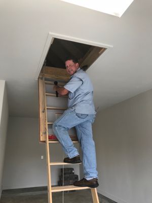 Climbing up into the attic during a home inspection.