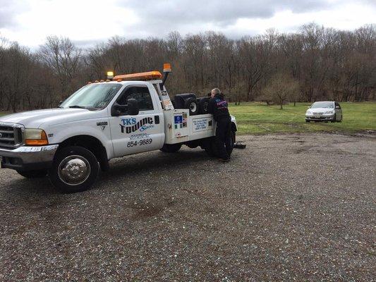 TK's Towing Services moving a car out of the mud in a slippery situation