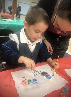 Seamus I nanny with his mama painting an ornament, he is so artistic and talented! POMS Winter Social we were invited to!