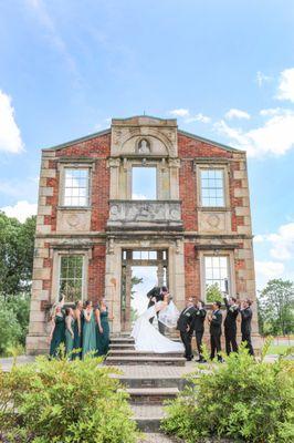 A destination wedding portrait of a groom dipping his bride while the bridal party look on. By wedding photographer from Brooks, GA.