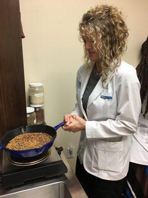 SCUHS Ayurveda student preparing herbs for a Pinda Sweda herbal bolus body therapy.