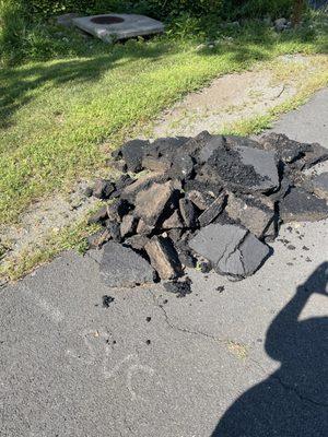 Piles of debris left behind by United Paving and Masonry after paving the driveway.