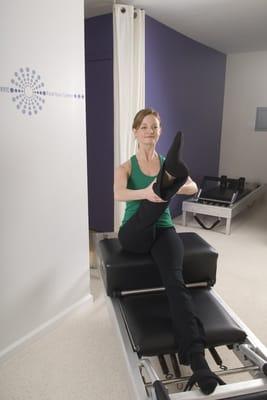 Kristen demonstrating a Pilates Reformer exercise