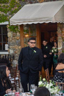 Black jacket, black dress shirt, black vest and Hunter green bow tie