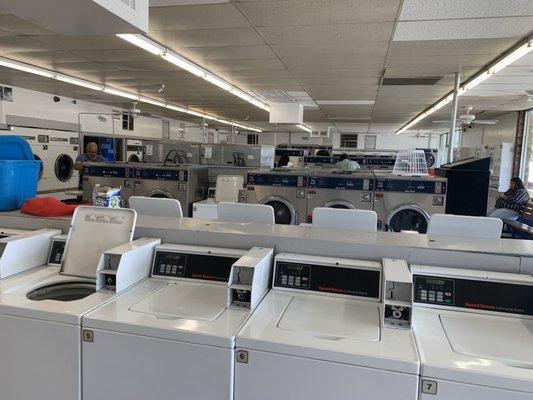 Inside of business, washing machines in the middle and dryers along the wall.