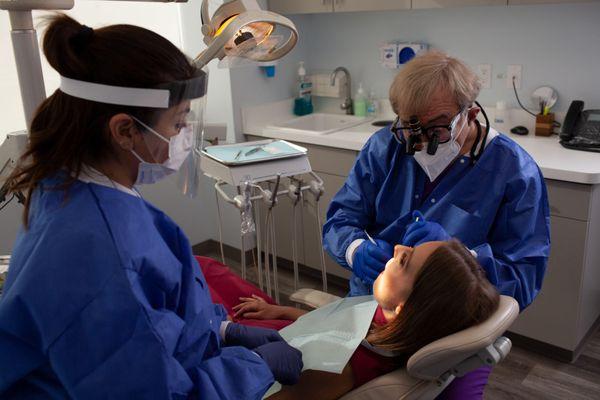 Dr. Solow cleans a client's teeth.