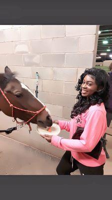 Me feeding rhapsody the (horse)she is blinded in one eye she's used as a therapy horse for stride also a 5th place. Ribbon holder.