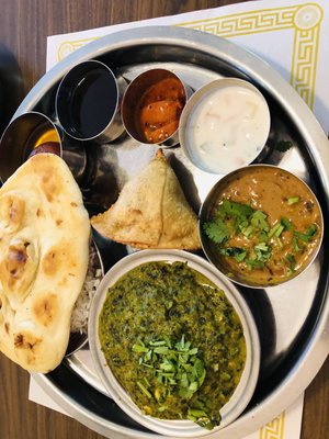 Lunch with Samosa appetizer, naan,-, Jeera rice, mango pickle, spinach and paneer curry, and lentils, Keer dessert