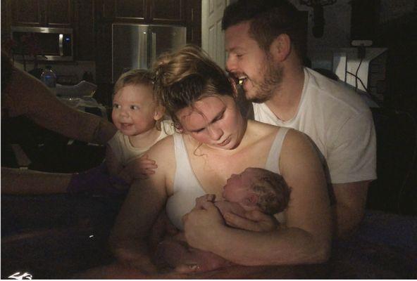 Birth of son next to mom dad and sister. In a pool