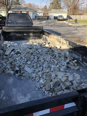 Loading up the dump trailer with concrete blocks from a demolition