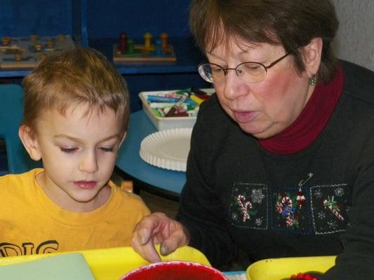 Teacher Marilyn working one-on-one.