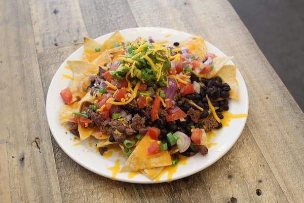 Nachos with meat, beans, and guacamole