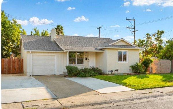 front of the house with lush lawn in front and concrete driveway