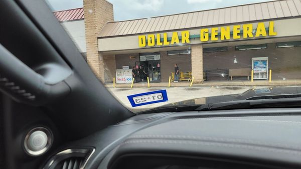 Three employees smoking at the store entrance while holding the door open.