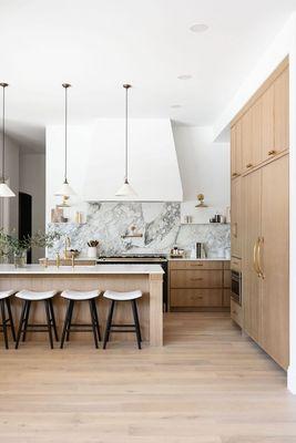 Classical kitchen with two tone cabinetry, marble slab with soft pendants.