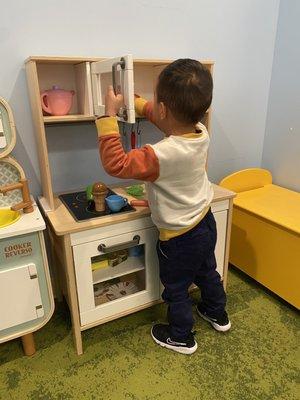 Playing with the play kitchen in the waiting room