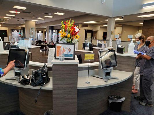 Check-in kiosks. Note staff on right helping check in.