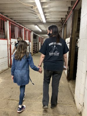 Very nice employee grasping a nervous young lady's hand and leading her to "meet" a few horses before an awesome trail ride!