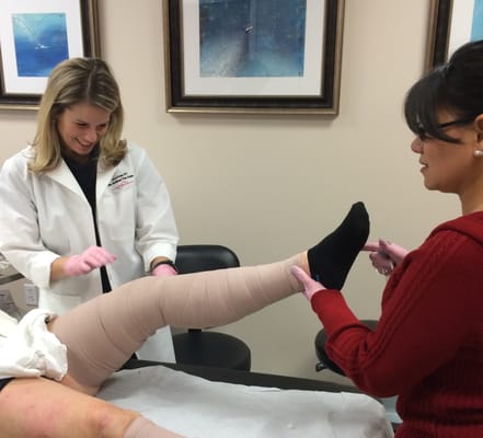 After sclerotherapy for spider veins, the leg is wrapped by Carrie Drum, RN and her assistant Gale Hernandez.