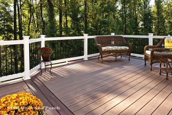 Vinyl deck using Wolf amberwood decking with rosewood border and Deckorators white PVC railing with black balusters.