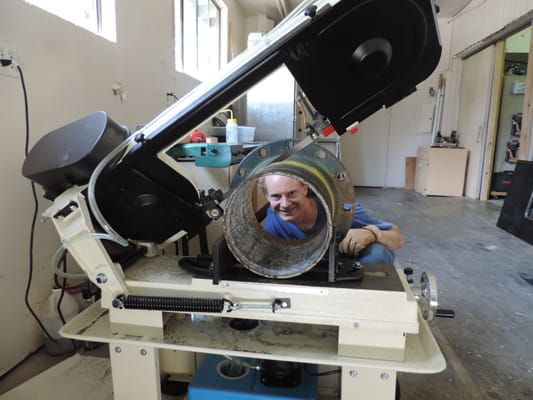 Omar Simon using the bandsaw to get at a large pipe failure.