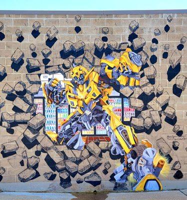 Cool mural art, Bumblebee smashing out from the store!