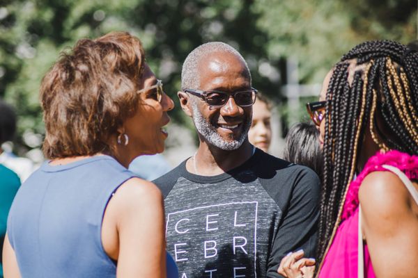 Celebrate Recovery leader talking and laughing with friends an outdoor event.