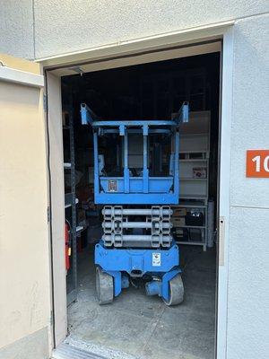 26' scissor lift stowed away in store storage unit.