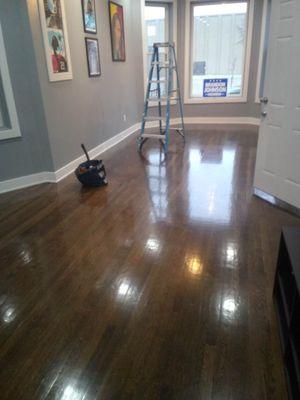 Installation of a hardwood floor with dark brown stain and polyurethane Shine.