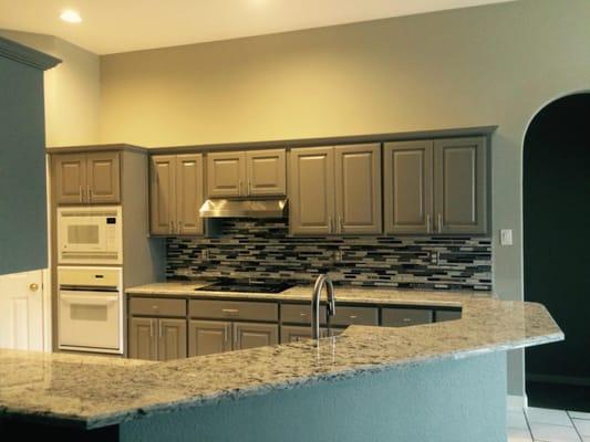 New paint on walls and cabinets, granite and her glass backsplash!