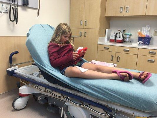 Our 9 year old awaiting stitches in her leg... Occupied with an iPad the nurse brought her