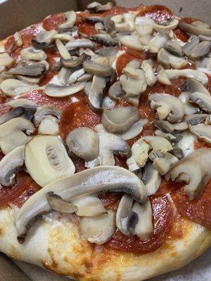 Fresh dough pepperoni and mushroom pizza